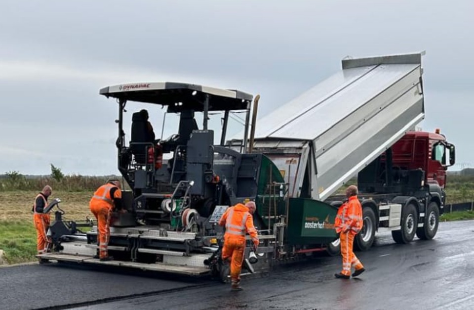 Bewerkt De laatste laag asfalt wordt aangebracht op de tijdelijke weg