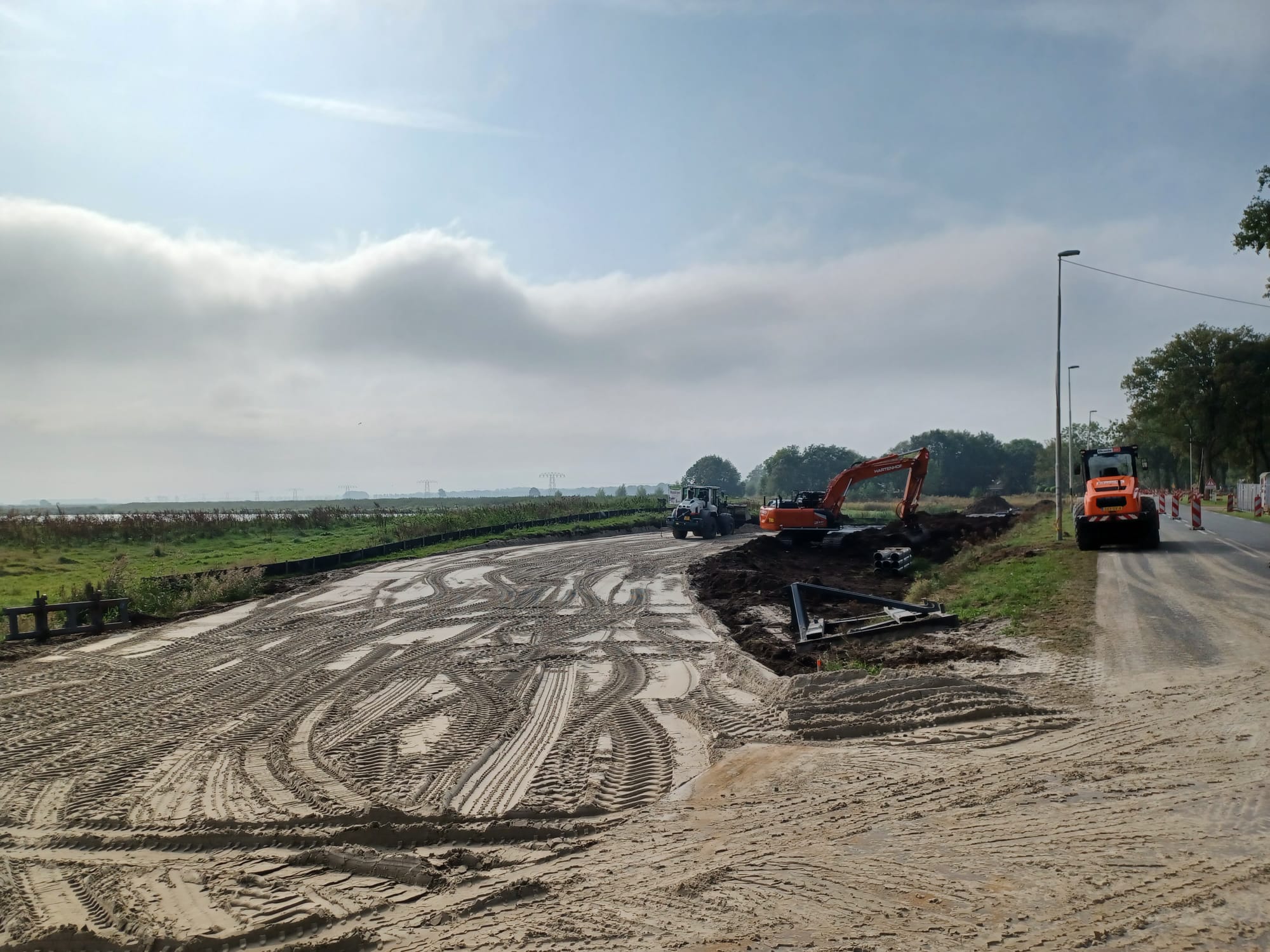 Het zand voor de tijdelijke weg wordt aangebracht